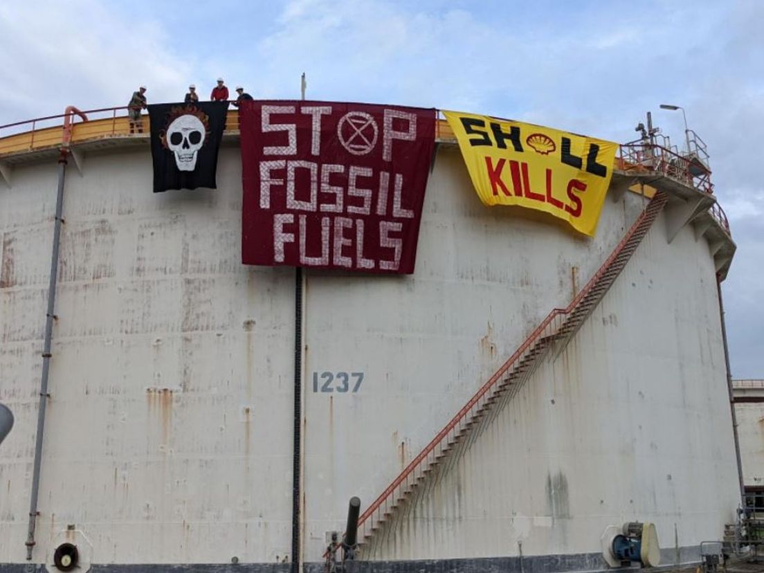 Klimaatactivisten staan op een tank bij Shell Pernis