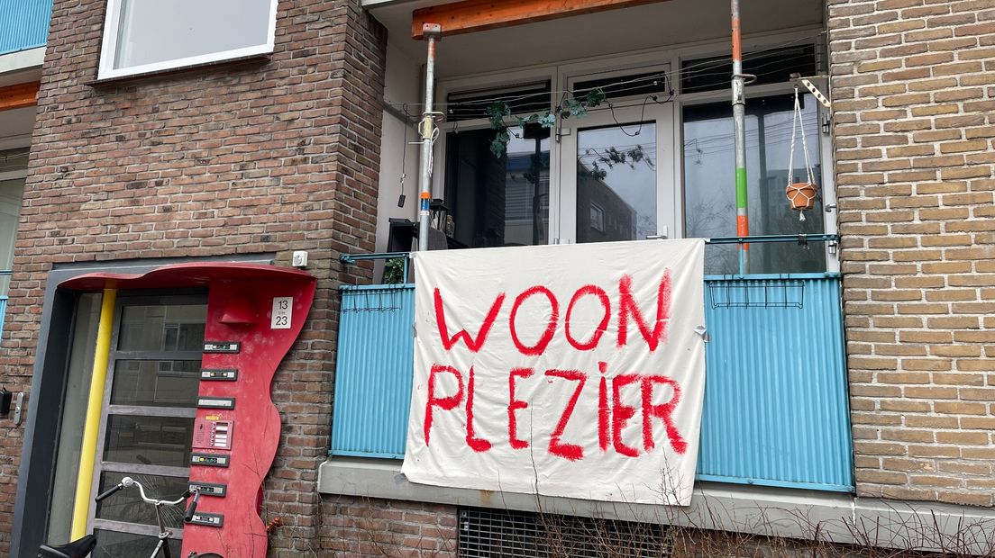 Een spandoek bij een gestut balkon in stadswijk Paddepoel