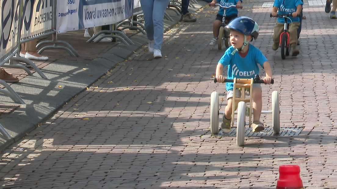 Op de loopfiets, genietend van het publiek langs de kant.