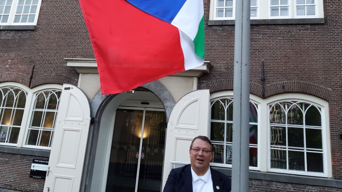 Hanne Wilzing hijst de Grunneger vlag bij de Oude Lutherse Kerk in Amsterdam