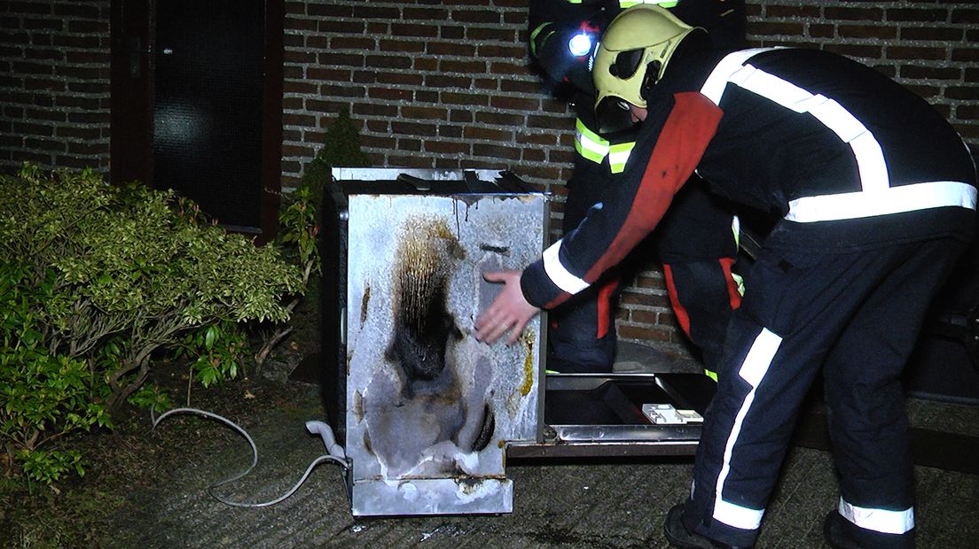 Brandweerlieden bekijken de uitgebrande vaatwasser