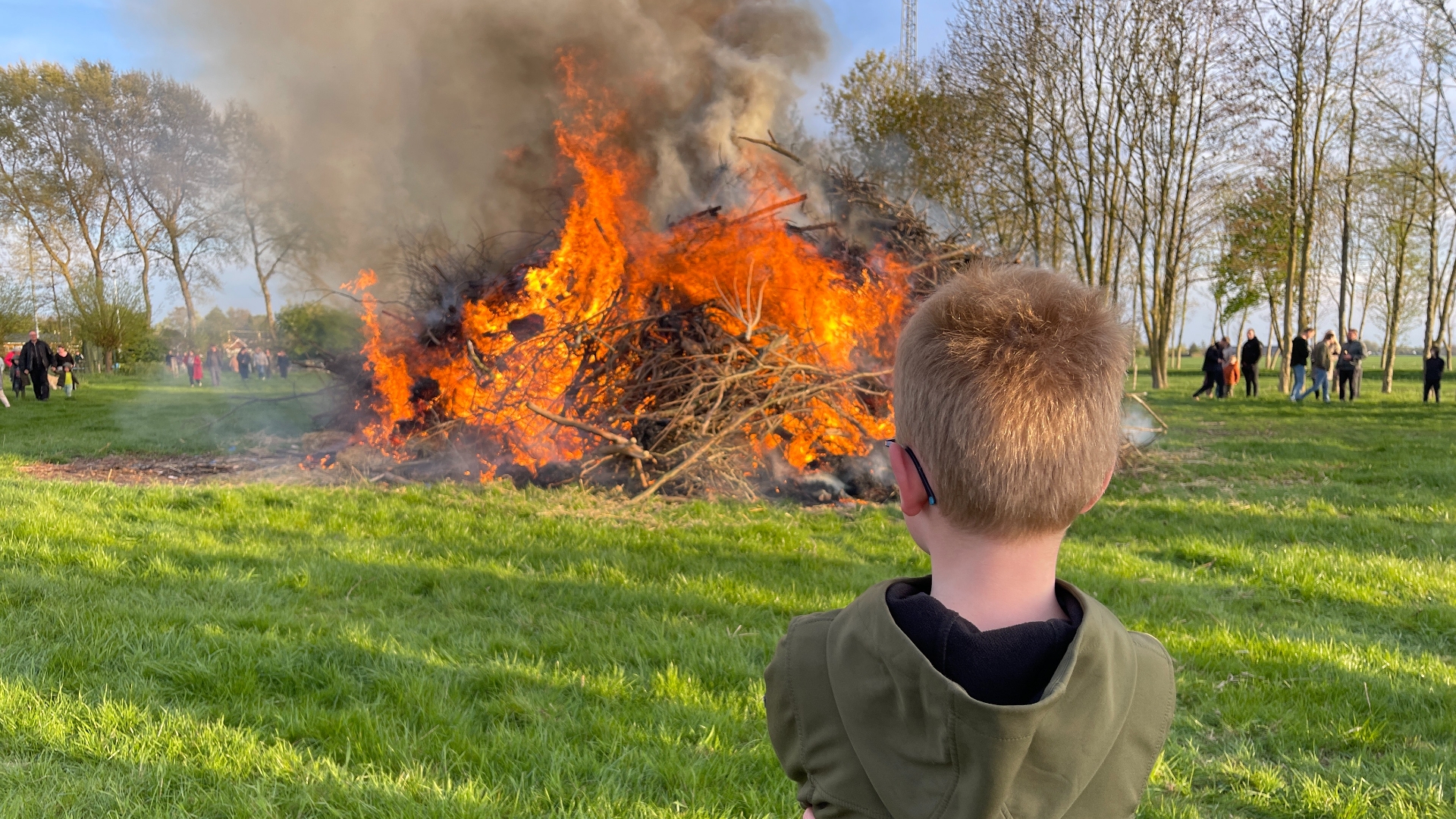 Een jongen kijkt naar het paasvuur in Drieborg