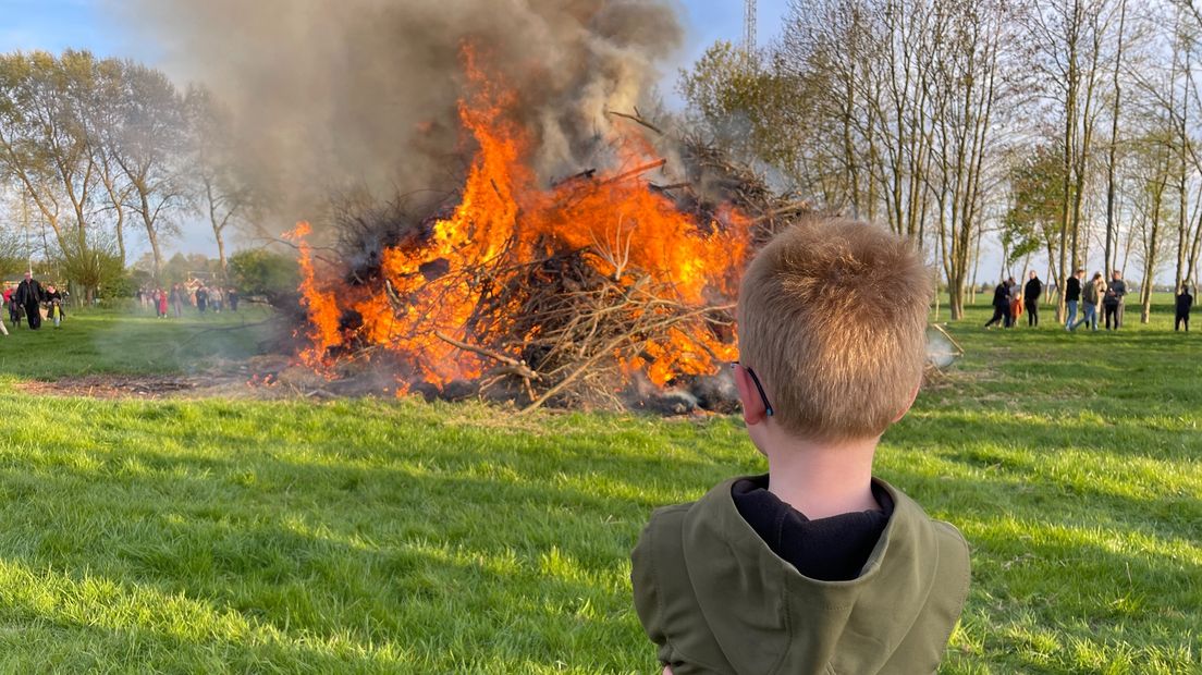 Een jongen kijkt naar het paasvuur in Drieborg