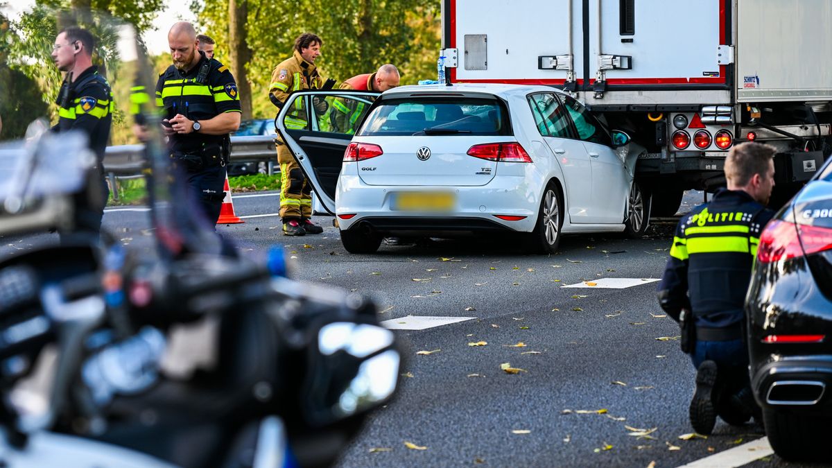Auto schuift onder vrachtwagen, verkeer op snelweg wordt omgeleid