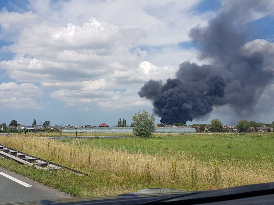 De rookpluim van de brand is van ver te zien.