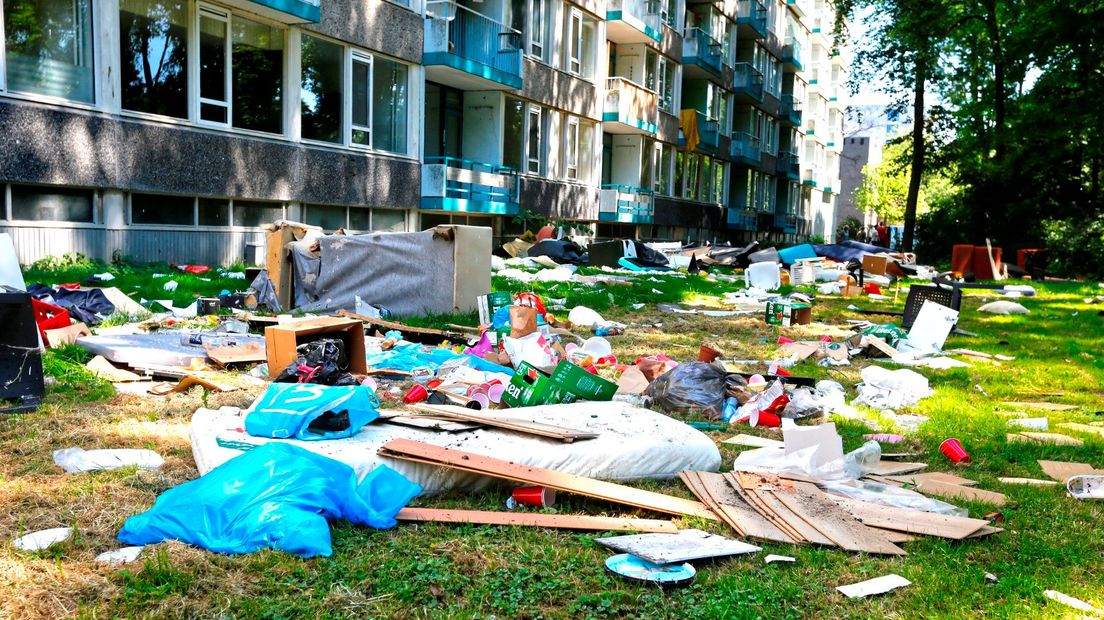 Het grasveld voor de flat ligt bezaaid met troep.