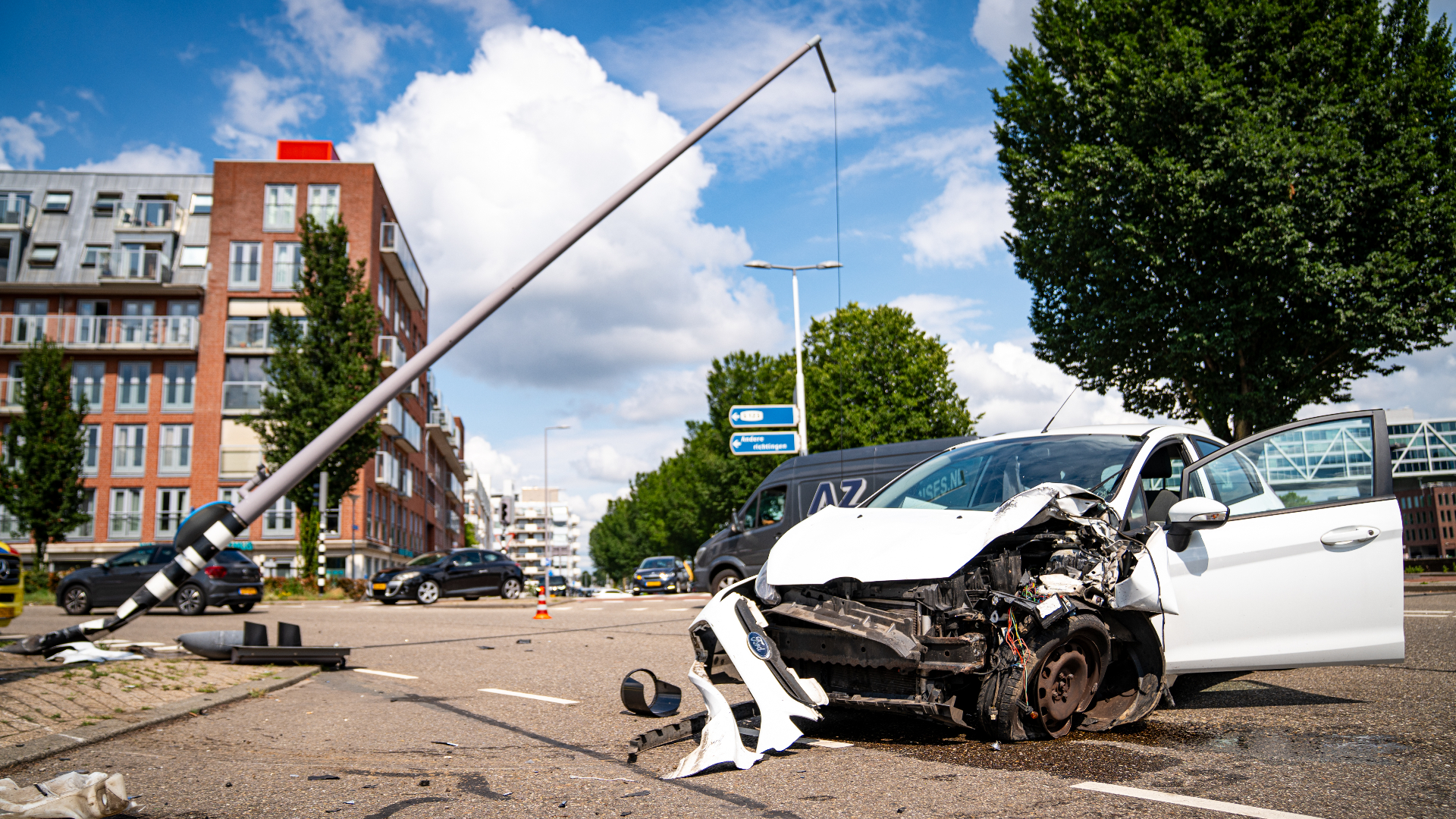 Lantaarnpaal scheef na botsing auto: bestuurder gewond naar ziekenhuis.