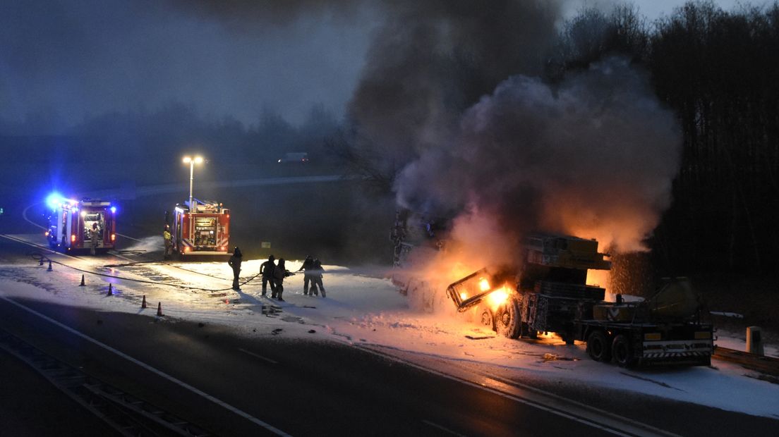 Brandweerlieden blussen de kraanwagen