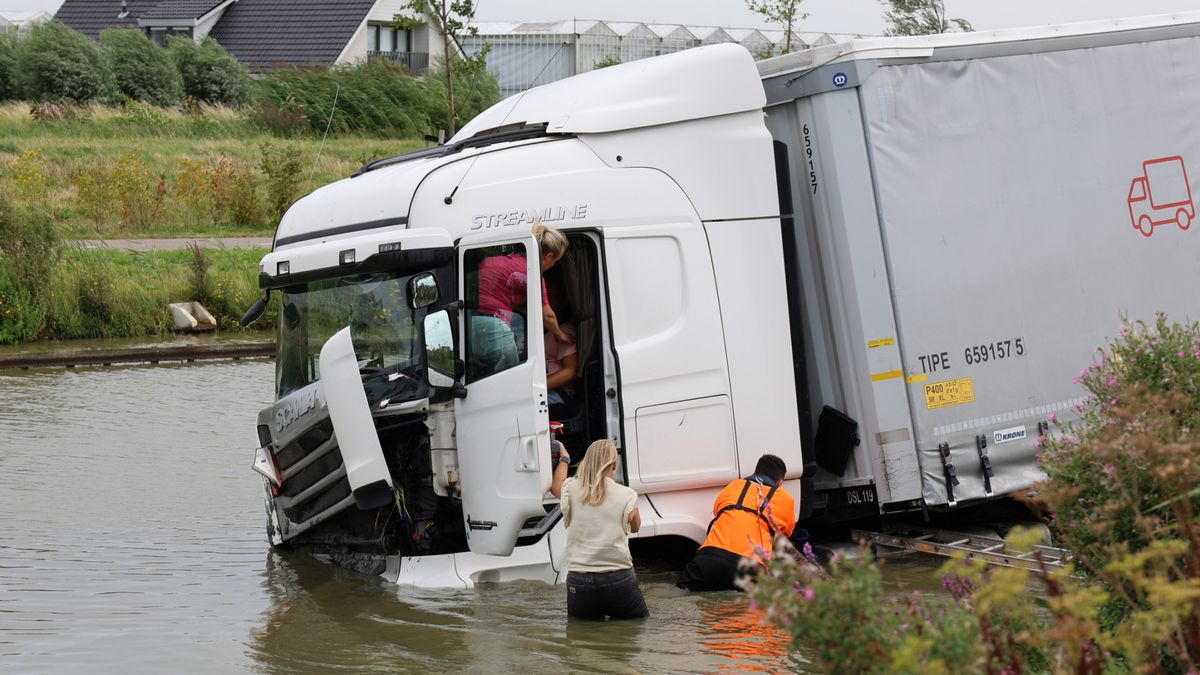 Omstanders springen in water om vrachtwagenchauffeur te redden