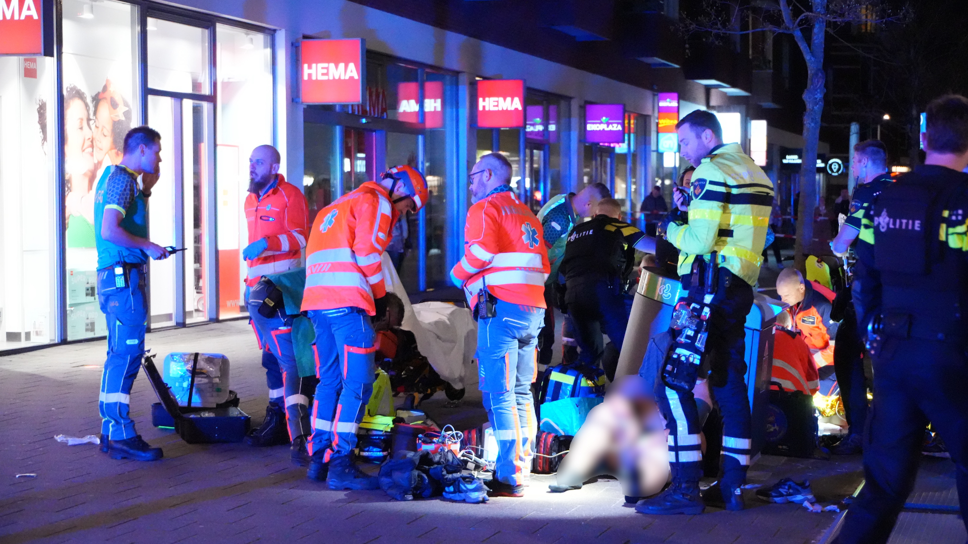 Hulpverleners buigen zich over het slachtoffer.