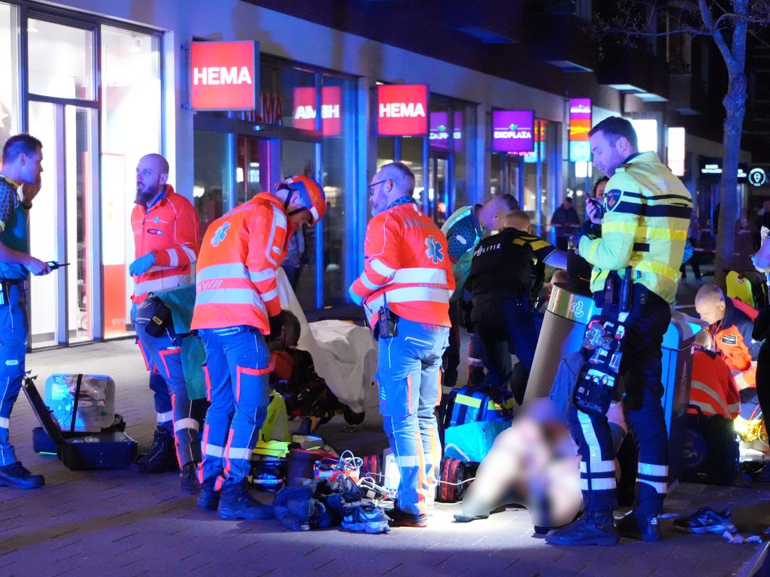 Hulpverleners buigen zich over het slachtoffer.