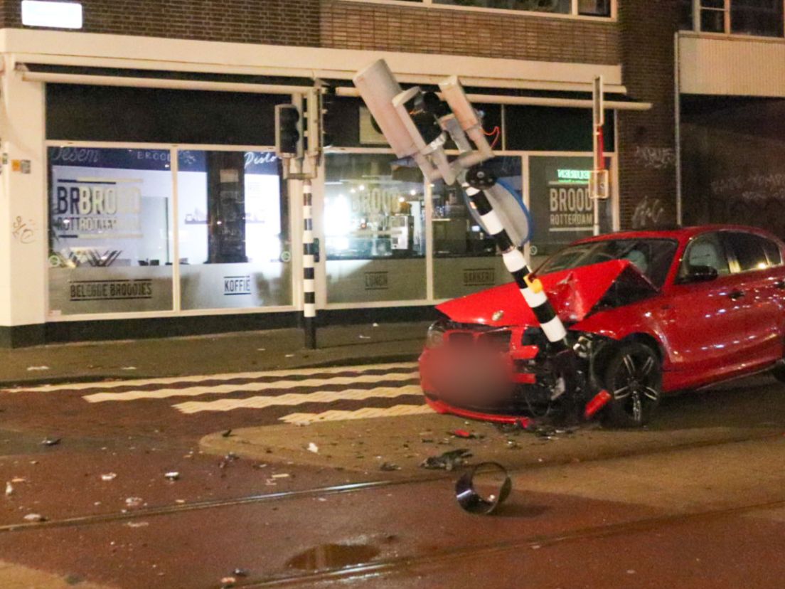 De auto en het verkeerslicht raakten flink beschadigd.