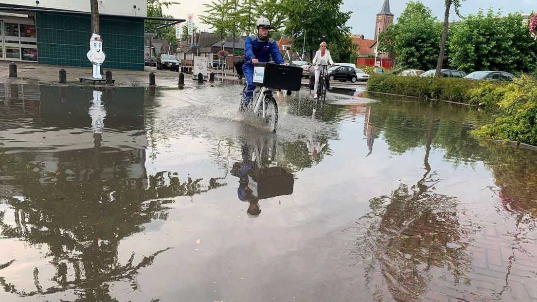 Fietsen door straten die vol water staan in Hardenberg
