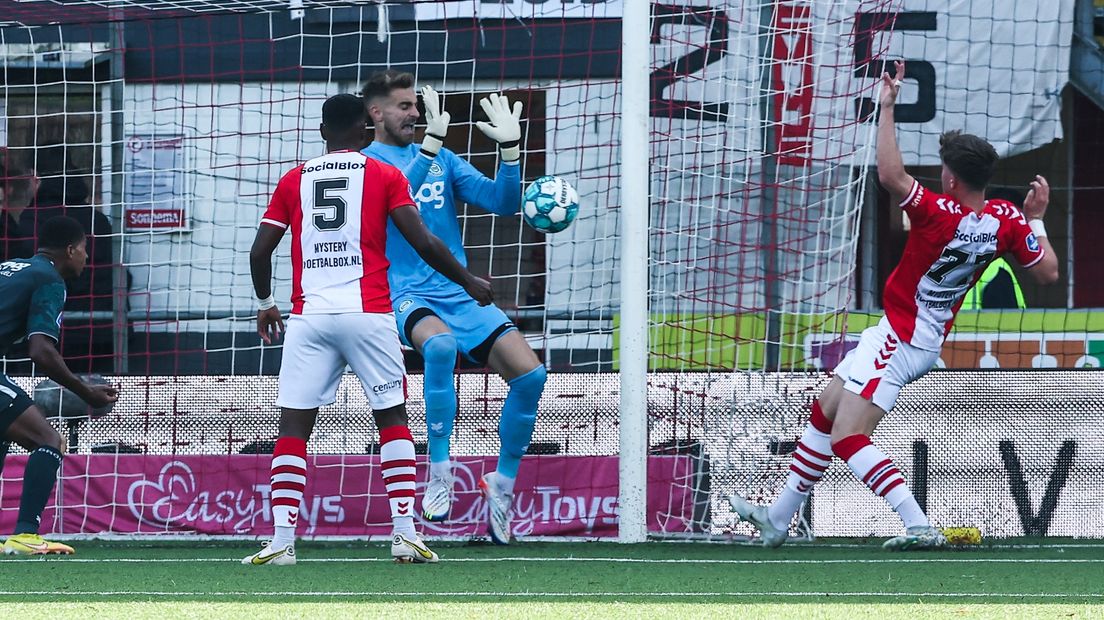 Peter Leeuwenburgh redt van dichtbij op een inzet van FC Emmen-aanvaller Ole Romeny