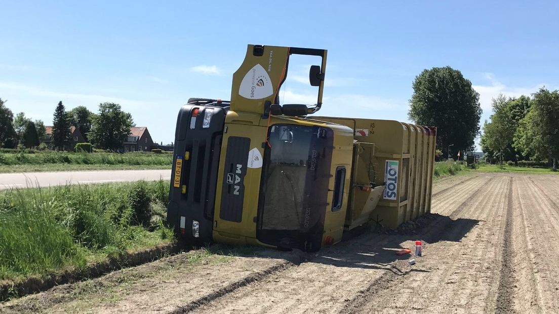 De vuilniswagen raakte van de weg en kwam op z'n kant terecht