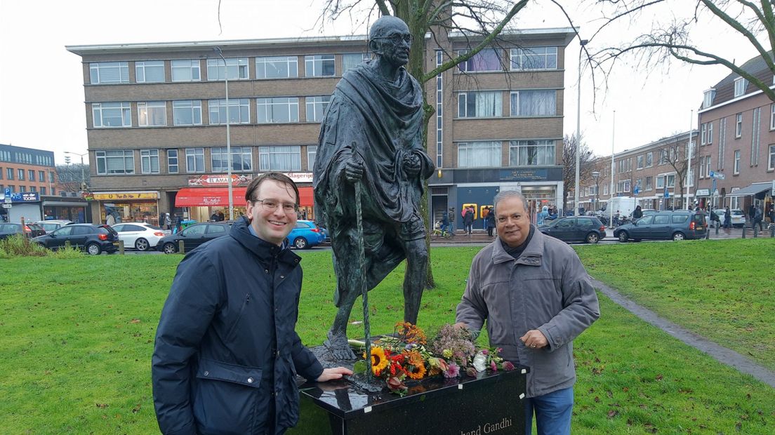 Robert Barker (Partij voor de Dieren) en Rabin Baldewsingh (Sarnami Instituut) leggen bloemen bij het monument van Gandhi aan het Hobbemaplein