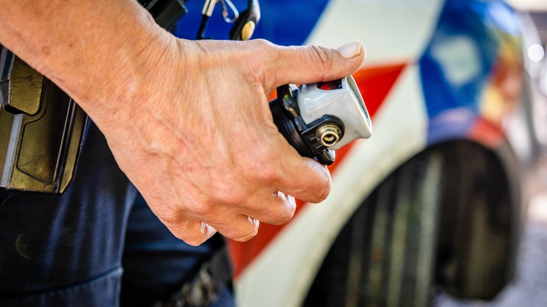 Een agent heeft pepperspray in de hand