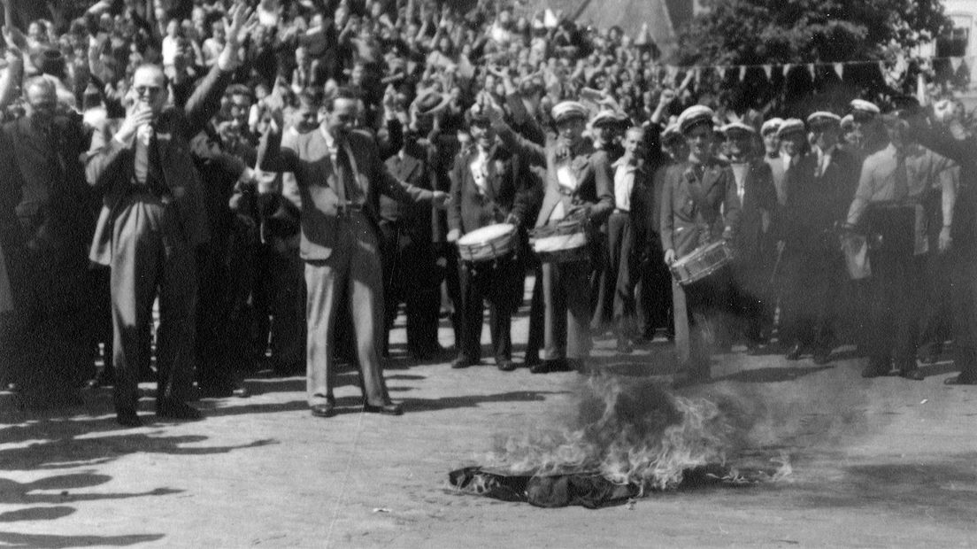 Uitzinnige inwoners van Veenendaal verbranden NSB-vaandels en een portret van Adolf Hitler.