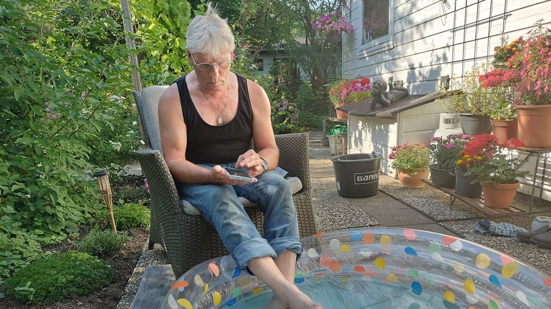 Ares de Haan zit lekker onder de parasol met zijn voeten in het water. 'Je moet je vooral niet druk maken'