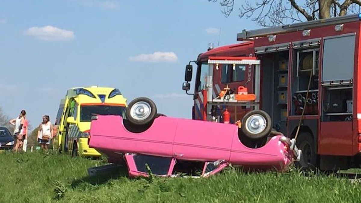 Oldtimer over de kop op dijk bij Kuinre, inzittenden behandeld door ambulancepersoneel