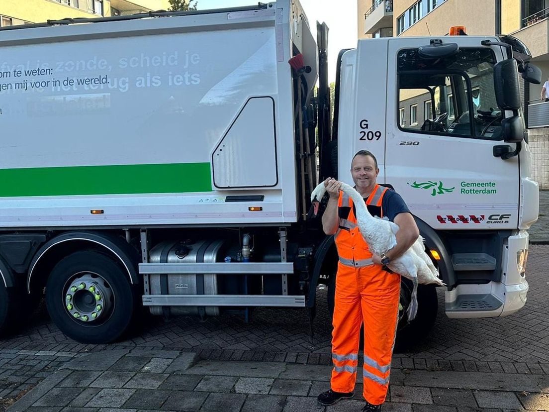 Patrick staat met de zwaan voor zijn vuilniswagen