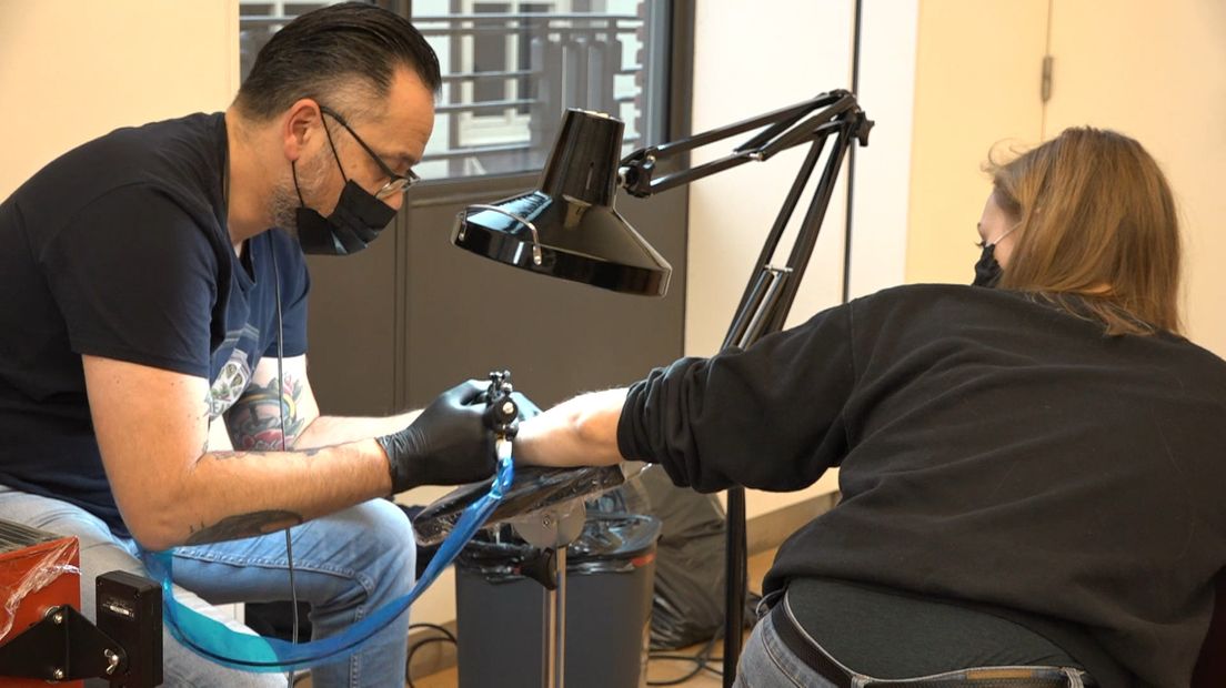 Een tatoeëerder aan het werk in het Mauritshuis
