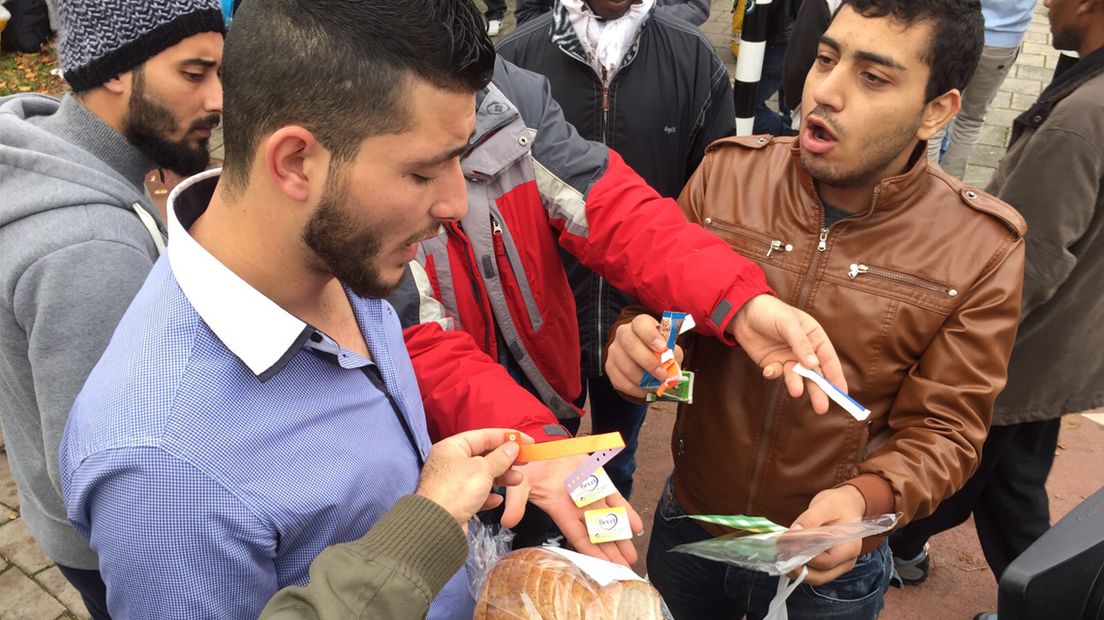 Boze asielzoekers in Den Haag tonen het eten waar zij ontevreden over zijn 