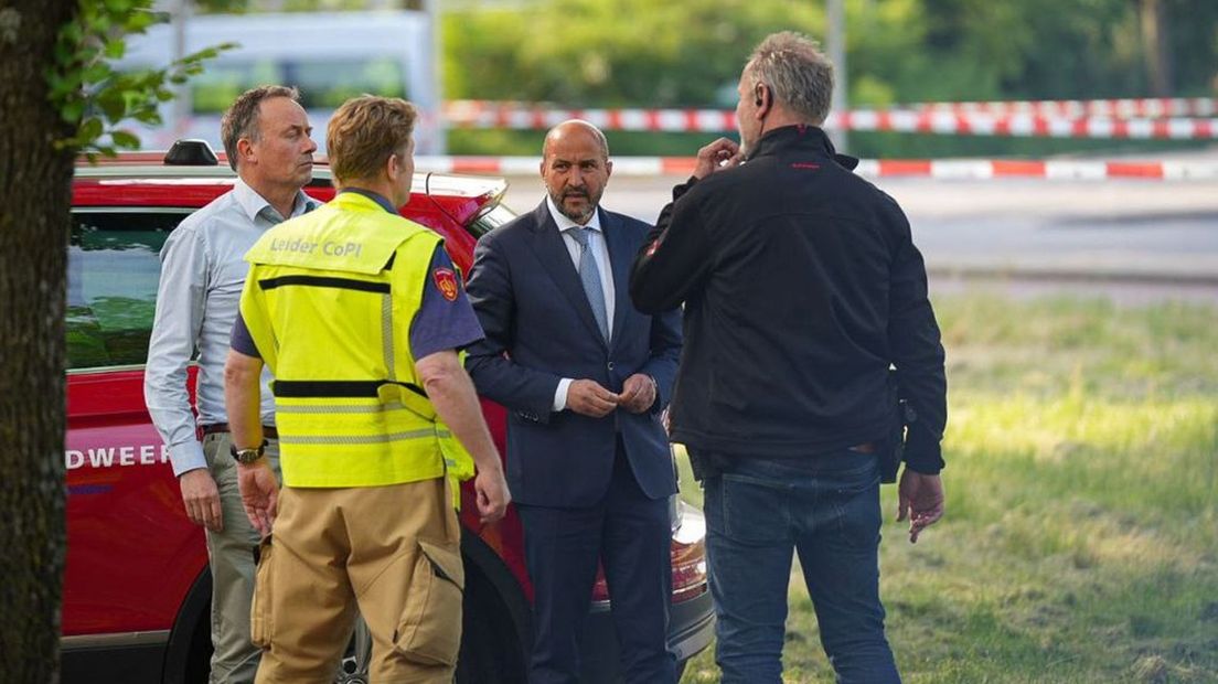 Burgemeester Marcouch spreekt met hulpverleners ter plaatse.