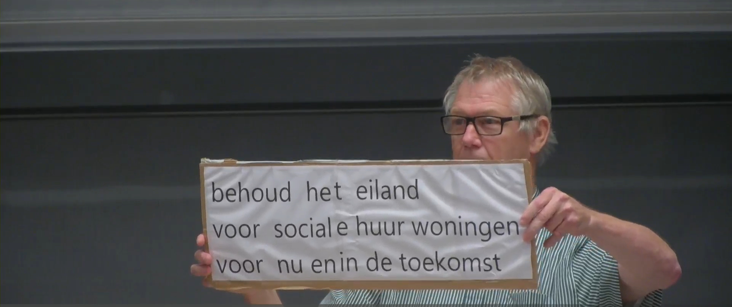 Deze bewoner hield tijdens zijn spreekrecht een bord omhoog