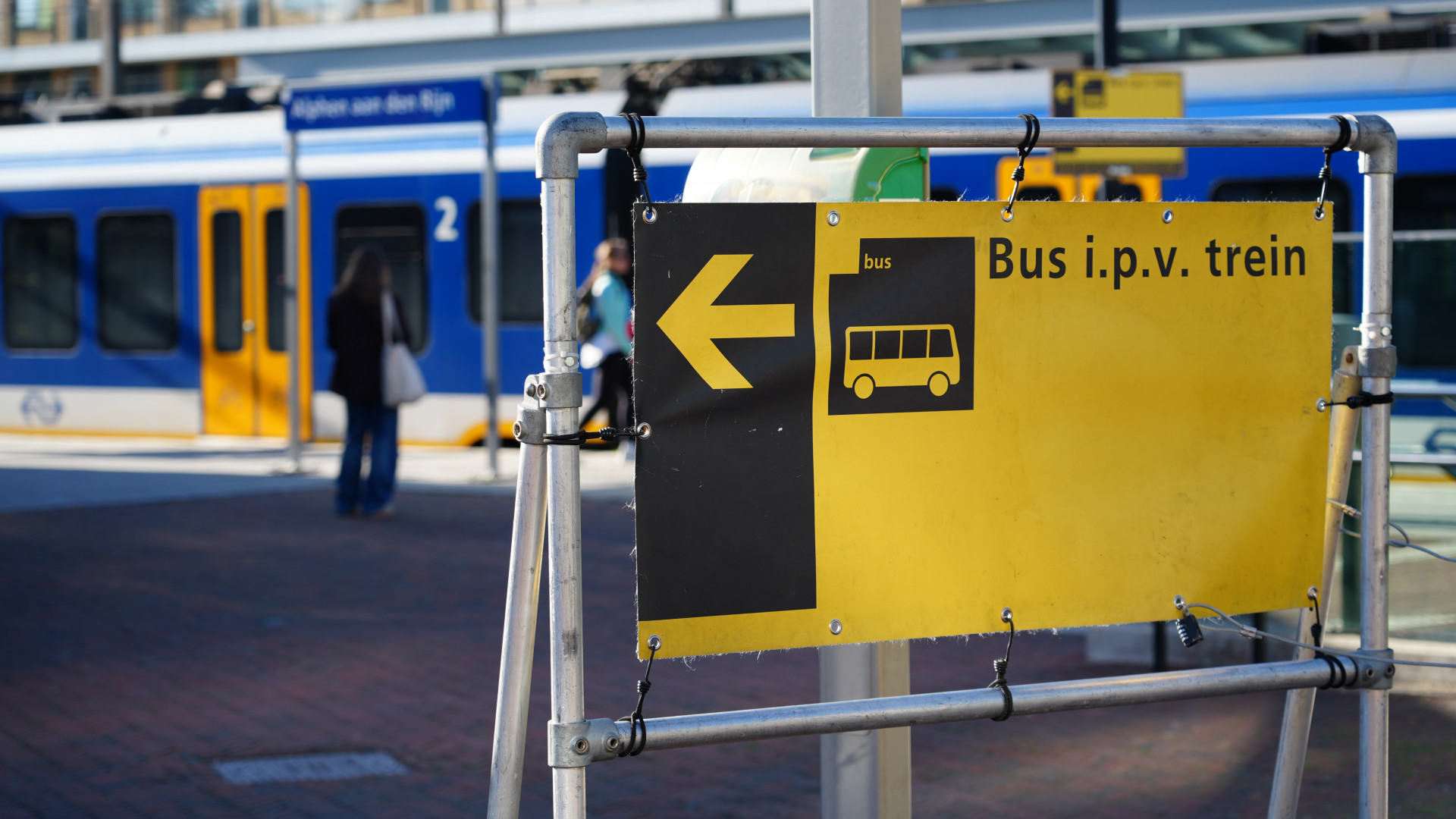 Met felgele borden worden reizigers naar het busplatform verwezen