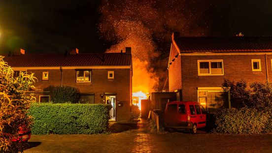 Vlammenzee achter woning, buurman blust vanaf dak