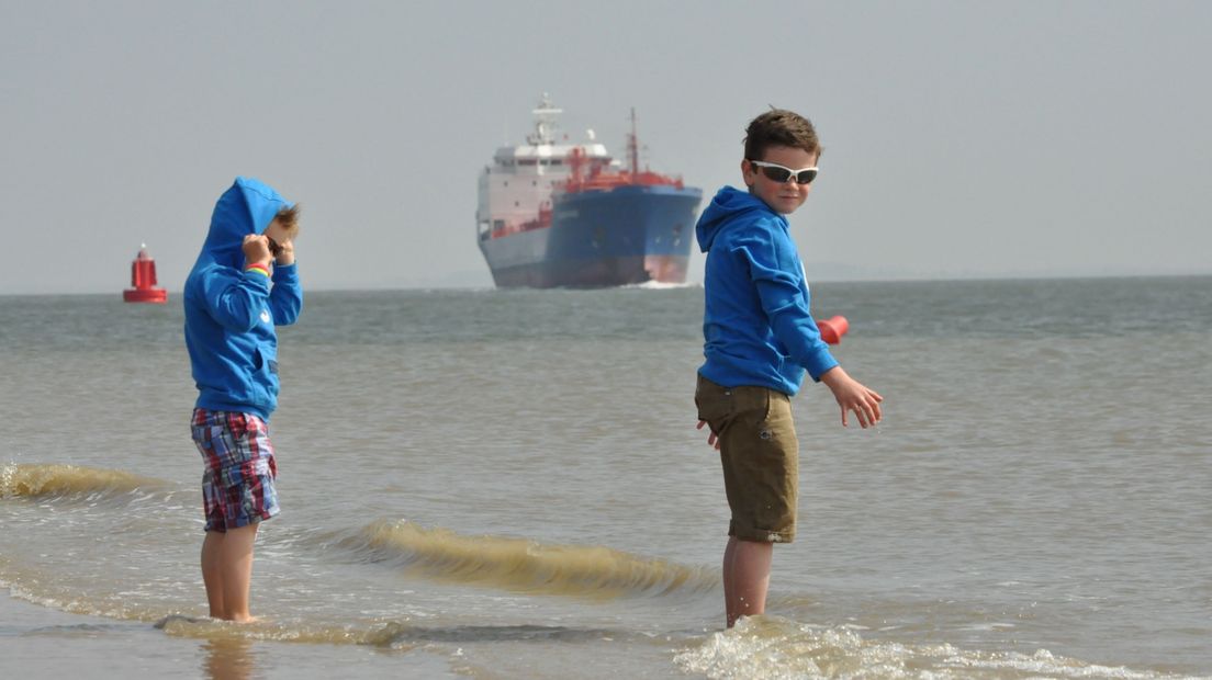 Groot schip vaart langs het strand