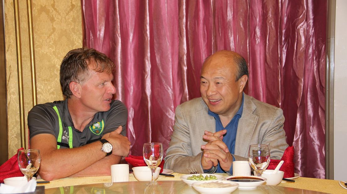 Trainer Fons Groenendijk zit naast Wang Hui tijdens het diner