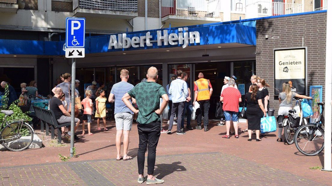 Winkelend publiek staat buiten de winkel