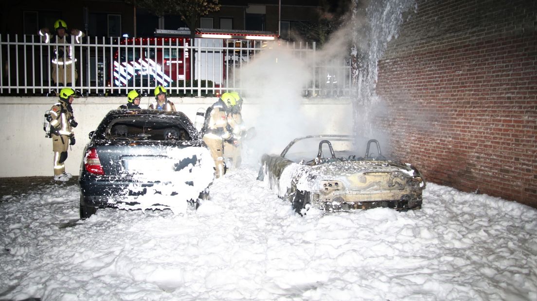 Brandweer blust brandende auto's in Goes met schuim