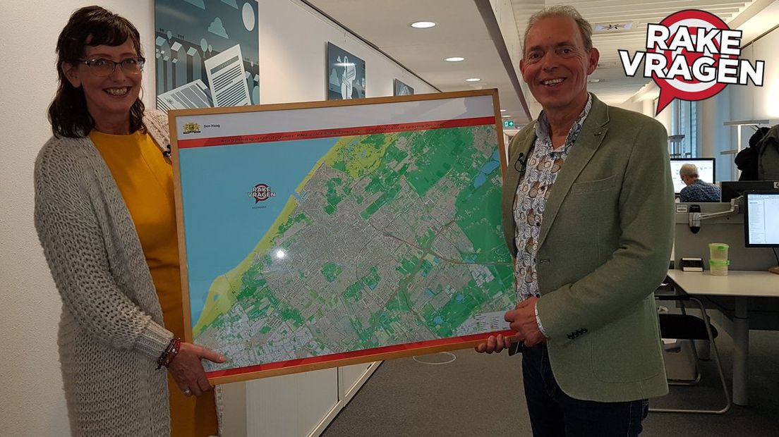 Vragensteller Tessa Bekker krijgt de kaart van Den Haag uit handen van Rolf Polman. 
