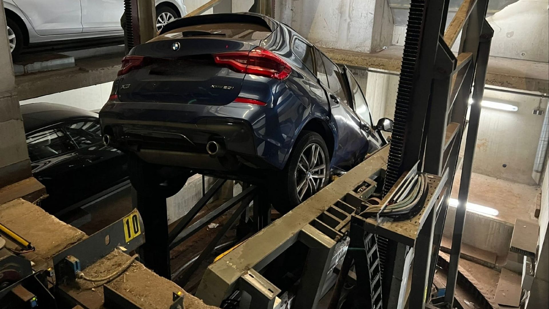 De auto bungelt tussen de begane grond en niveau min 2 in woontoren De Hoge Erf, augustus 2023