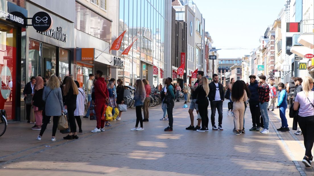 Een rij winkelend publiek in de Herestraat in Stad