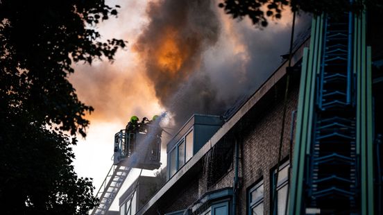 Vlammen slaan uit dak bij brand in woning, tientallen omwonenden geëvacueerd