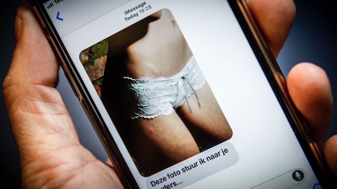 Illustratief beeld van een telefoon met naaktfoto.
