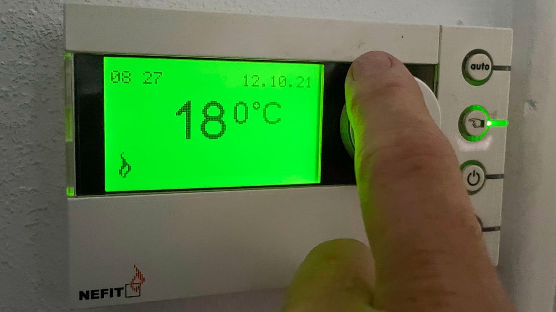 Iemand verandert de temperatuur op de thermostaat