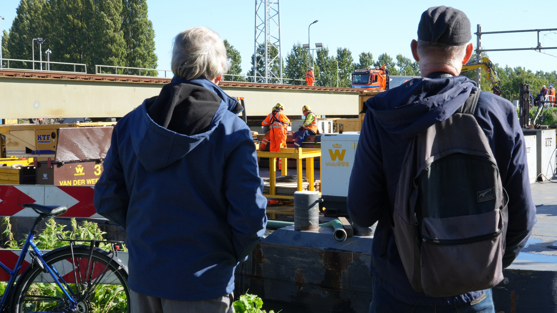 Nieuwsgierige omstanders bekijken het werk