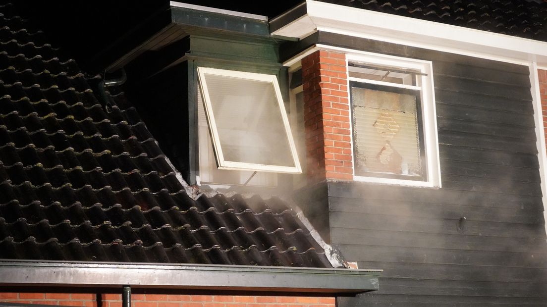 Rook uit een raam van de woning in Appingedam
