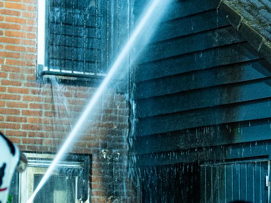 De brandweer blust de brand die na de explosie ontstond