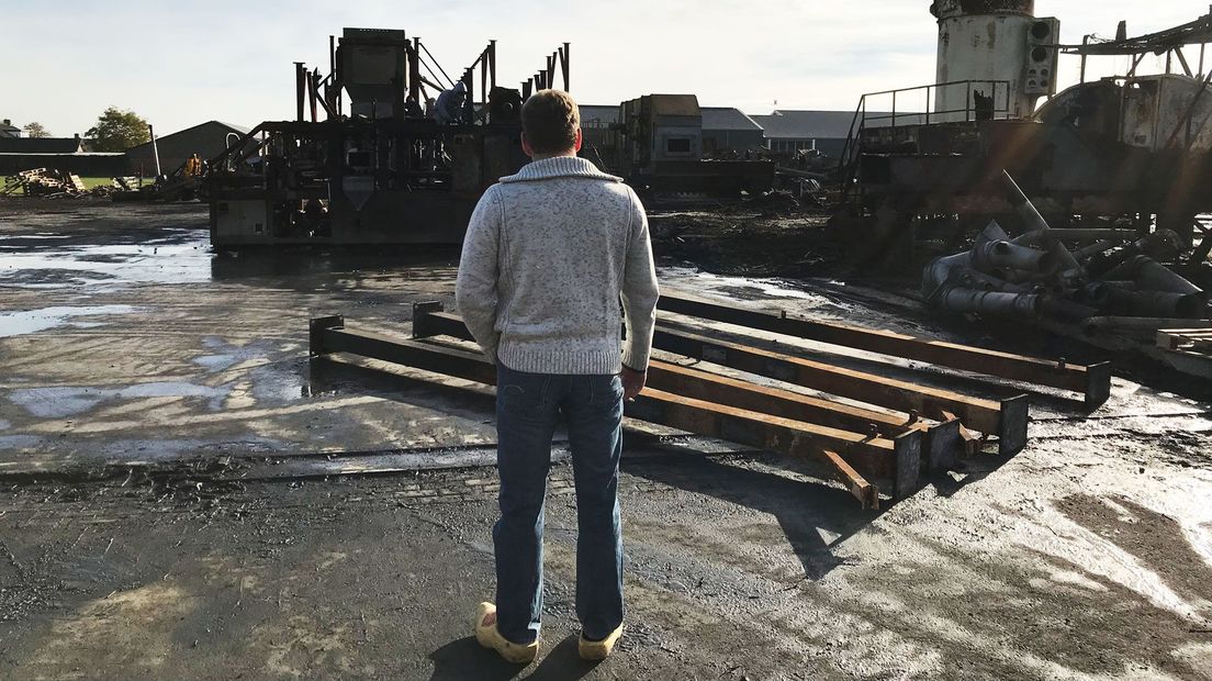 Boer Gert S. bekijkt de smeulende puinhoop na een van de branden bij zijn bedrijf in Werkhoven