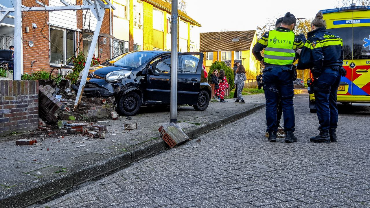 Ravage bij aanrijding in Enschede, stenen muurtje verwoest.