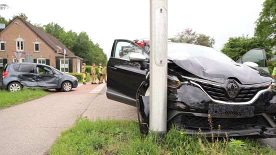 Aanrijding tussen twee auto's, lantaarnpaal beschadigd