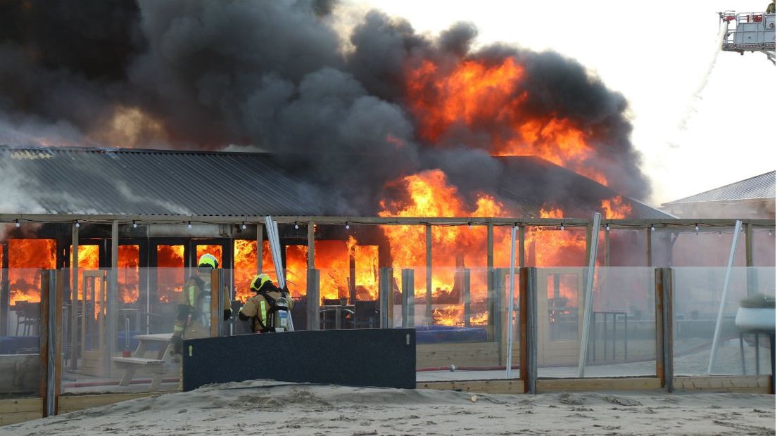 De vlammen slaan uit de strandtent. 