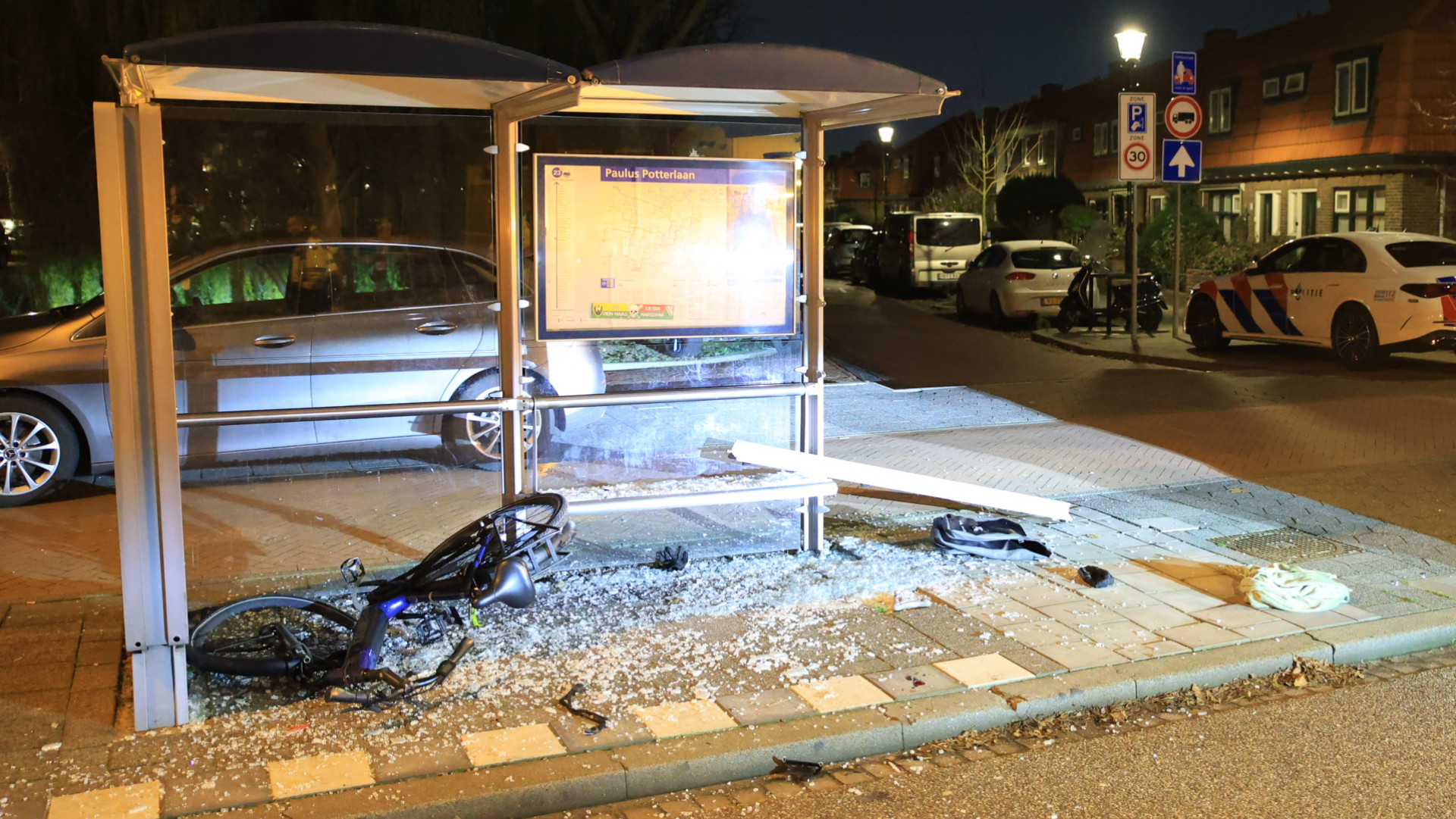 Fietser valt door glasplaat bushokje na botsing met auto.