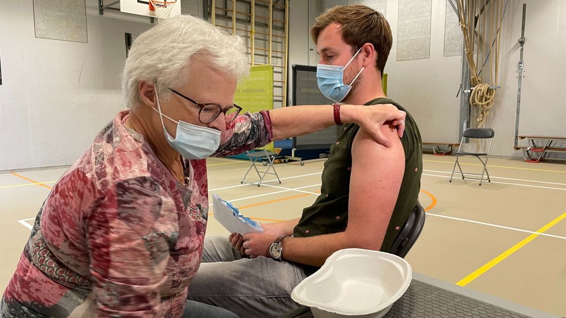 Een student laat zich op de Haagse Hogeschool vaccineren